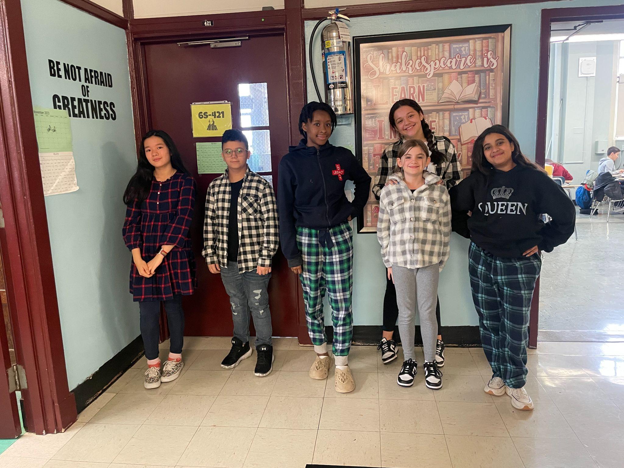 Six middle school students posing together in a school hallway