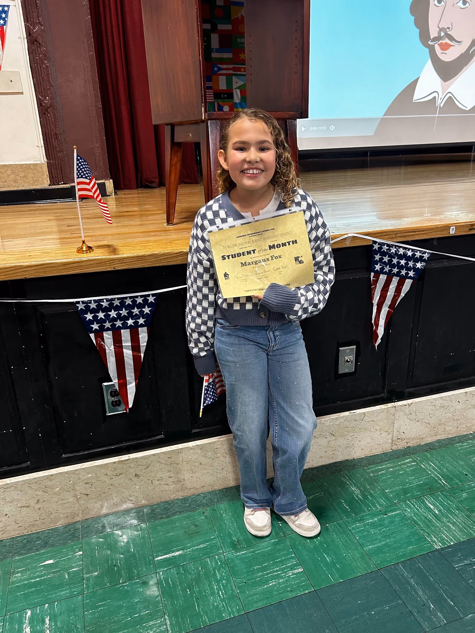 Student Margaux Fox holding her Student of the Month certificate