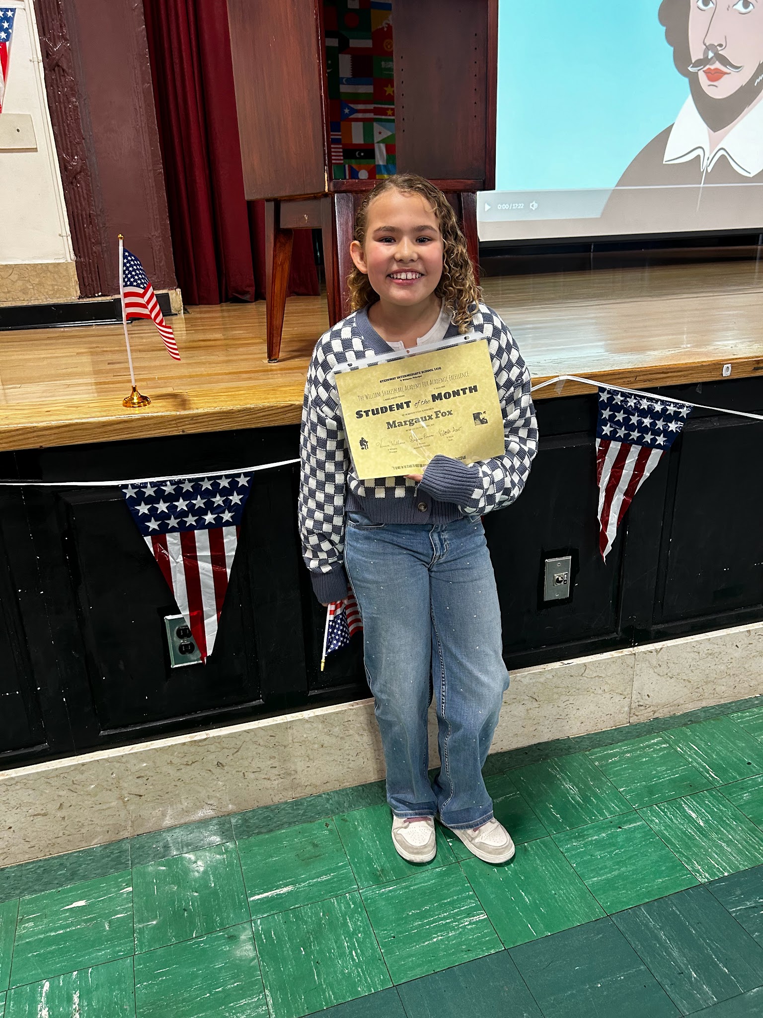 Student Margaux Fox holding her Student of the Month certificate