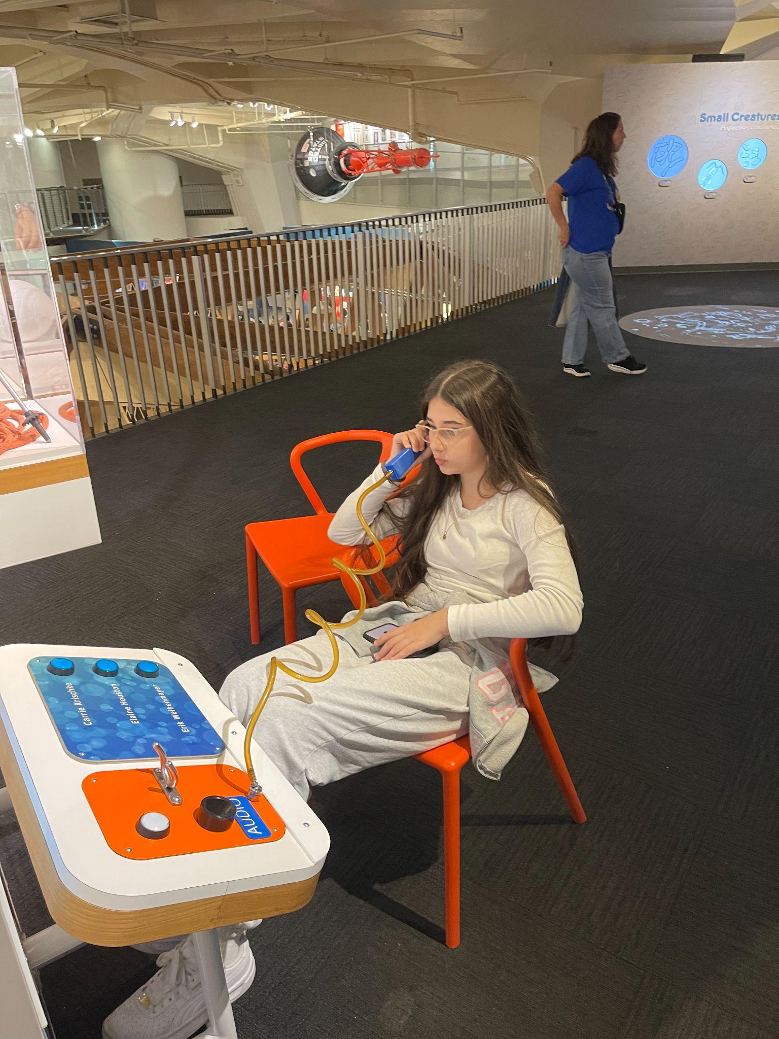 Student using an interactive audio exhibit at a science museum