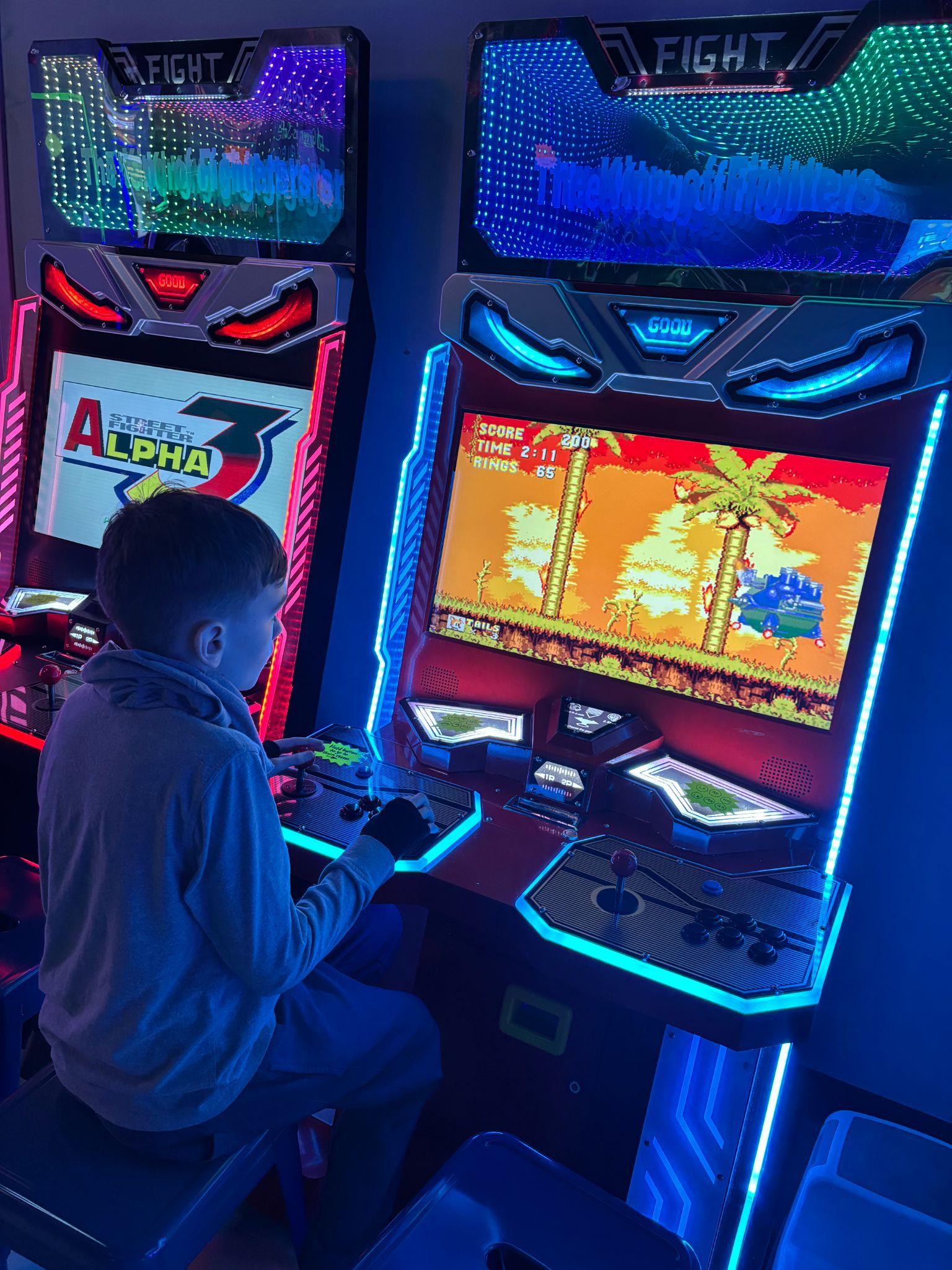 Student playing a Sonic the Hedgehog arcade game cabinet
