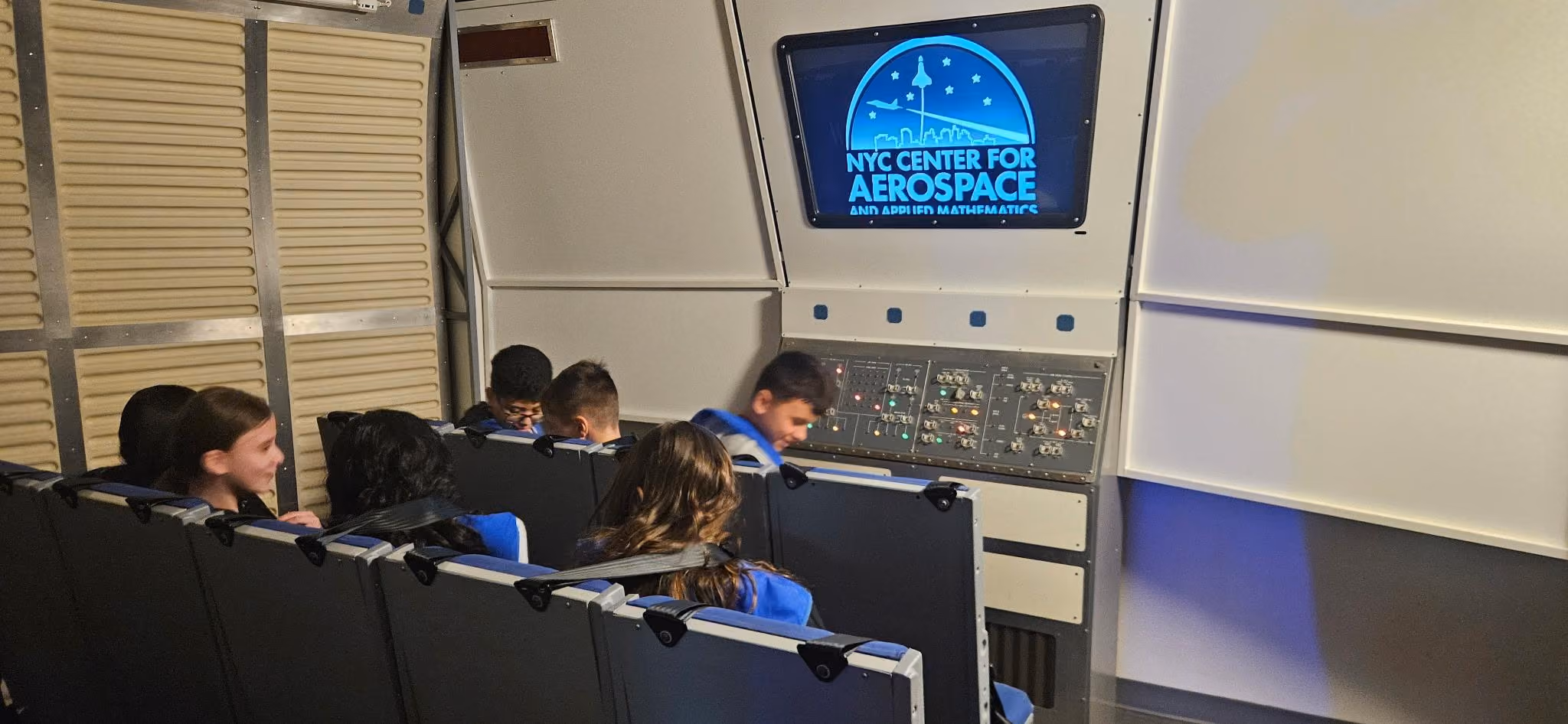 Students seated in aerospace simulator at NYC Center for Aerospace