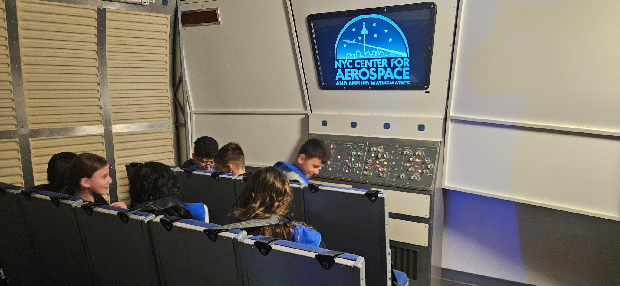 Students seated in aerospace simulator at NYC Center for Aerospace