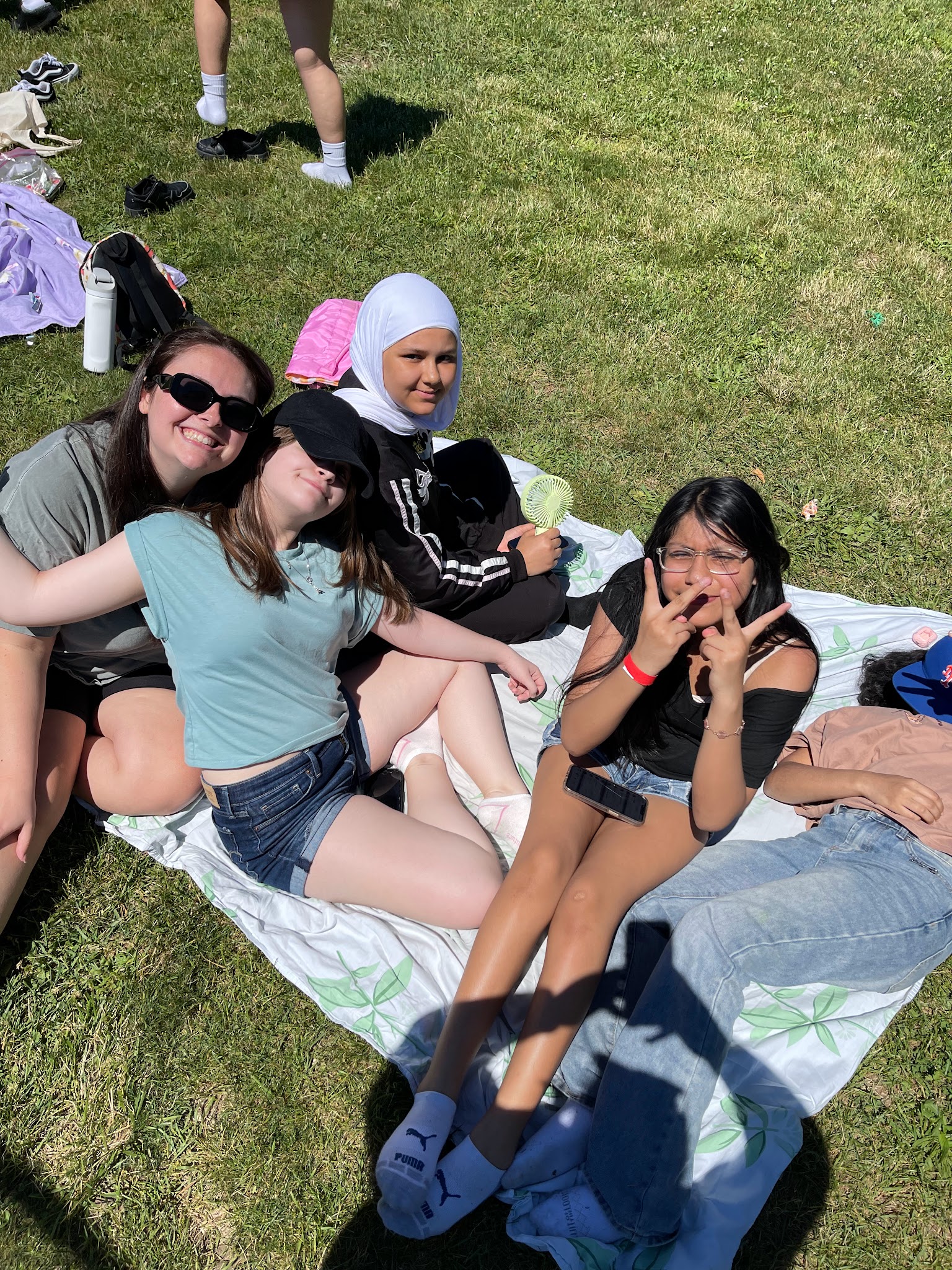 Students relaxing together on a blanket outdoors on grass