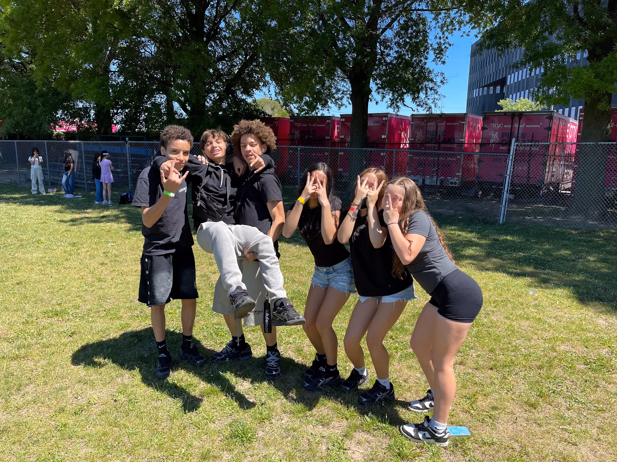 Six students posing together outdoors during a school event