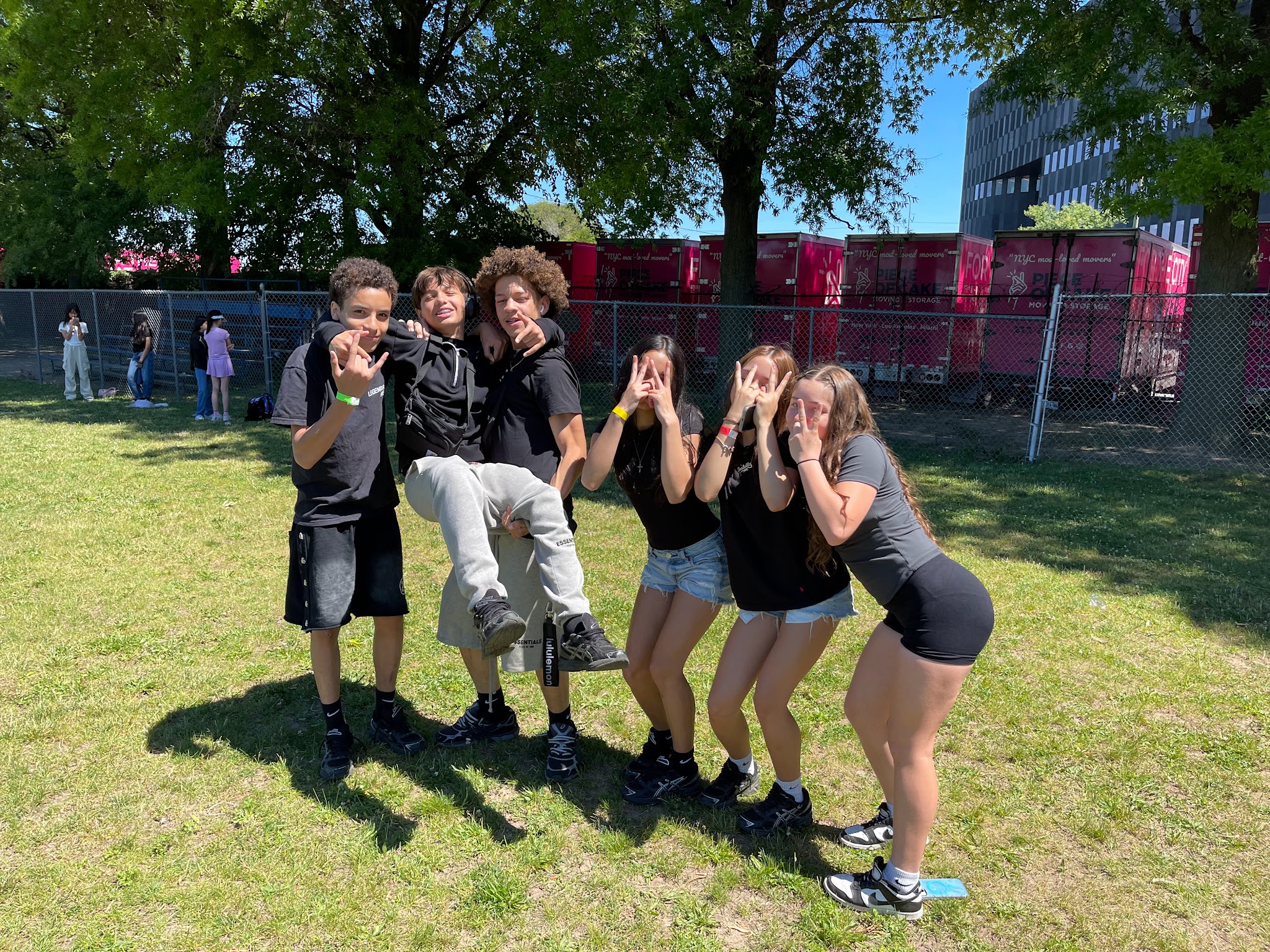 Six students posing together outdoors during a school event