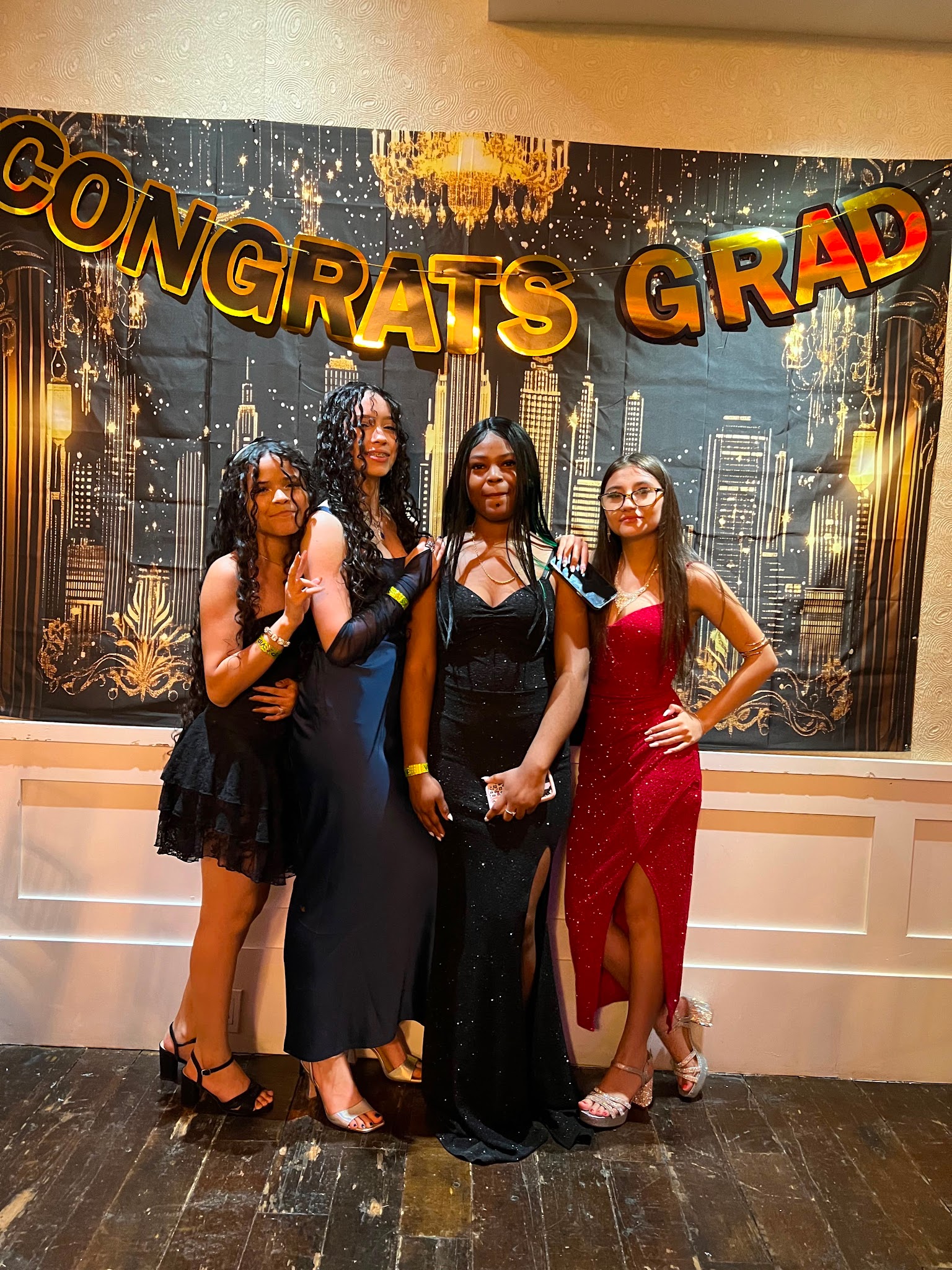 Four students posing together at graduation celebration event