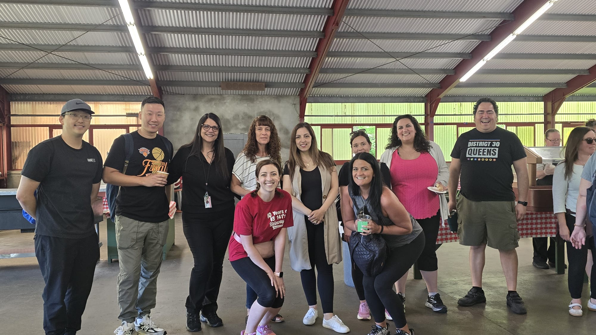 Staff members posing together at an outdoor school gathering event