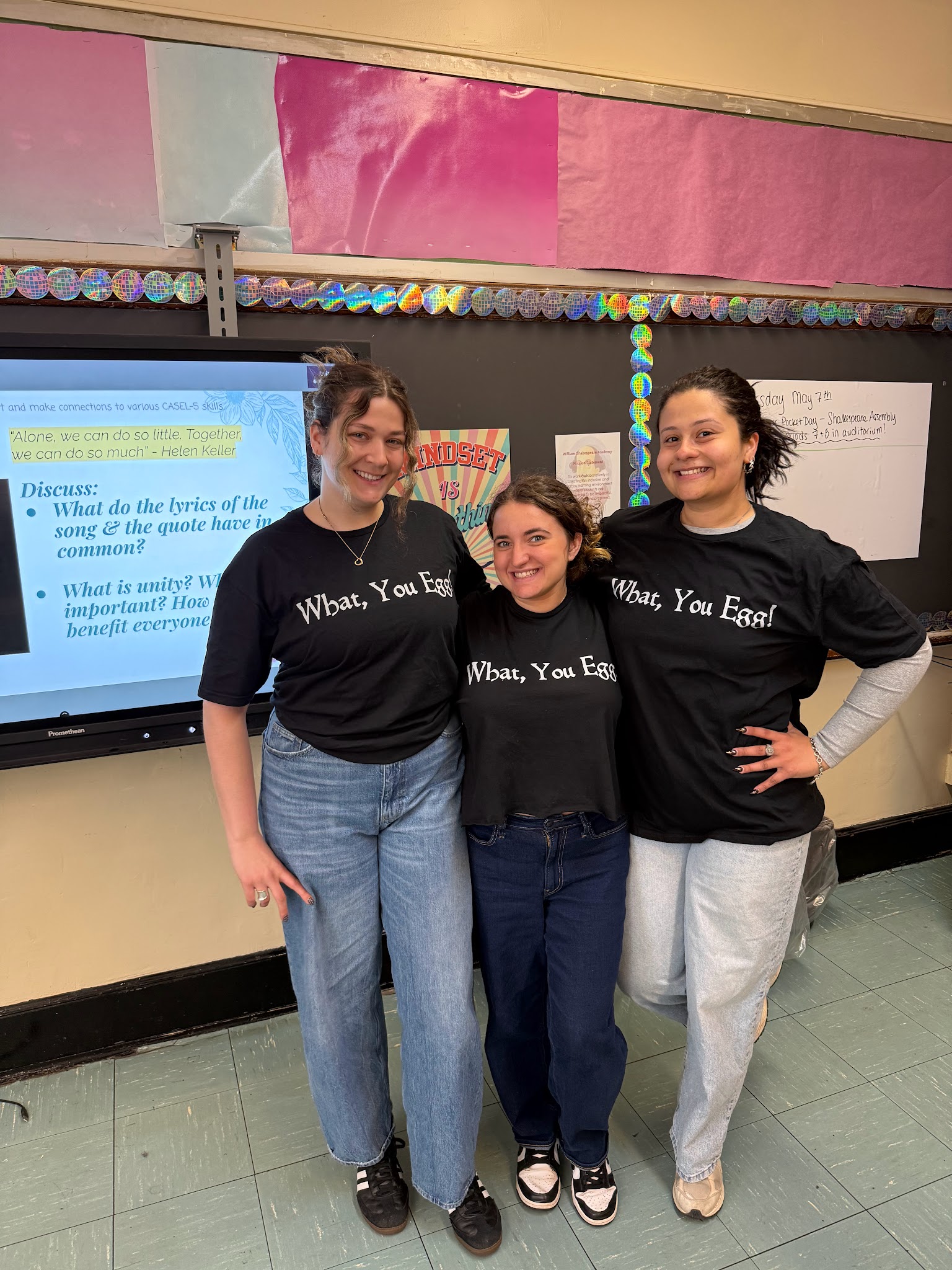 Three students wearing matching What You Egg shirts in classroom