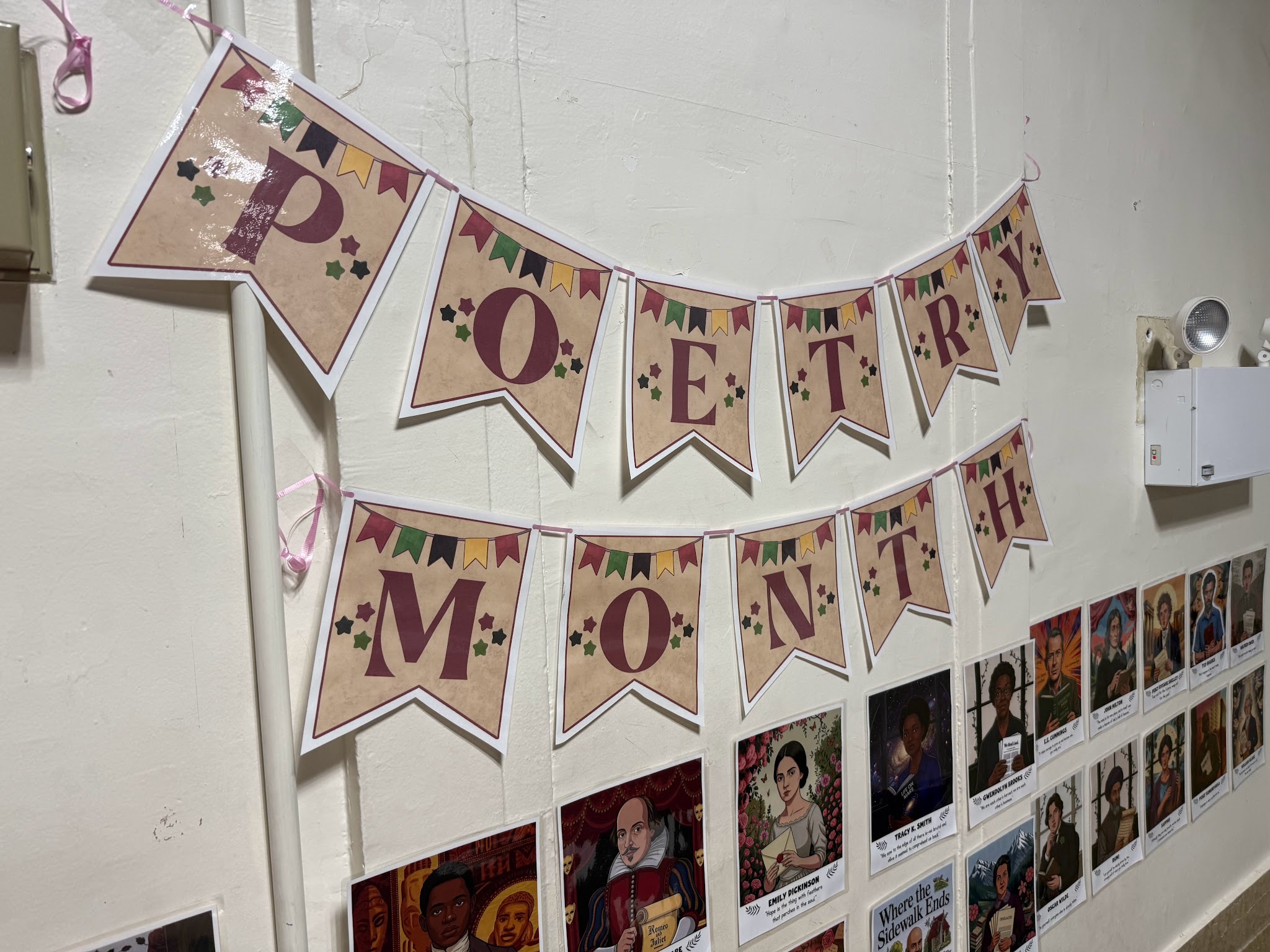 Poetry Month banner displayed above poet portraits on classroom wall