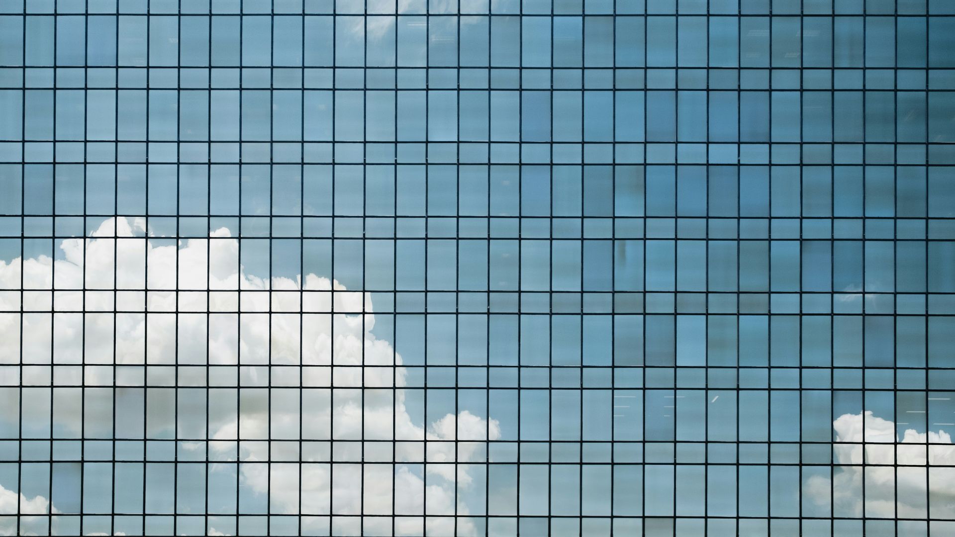 clouds reflected on a glass building