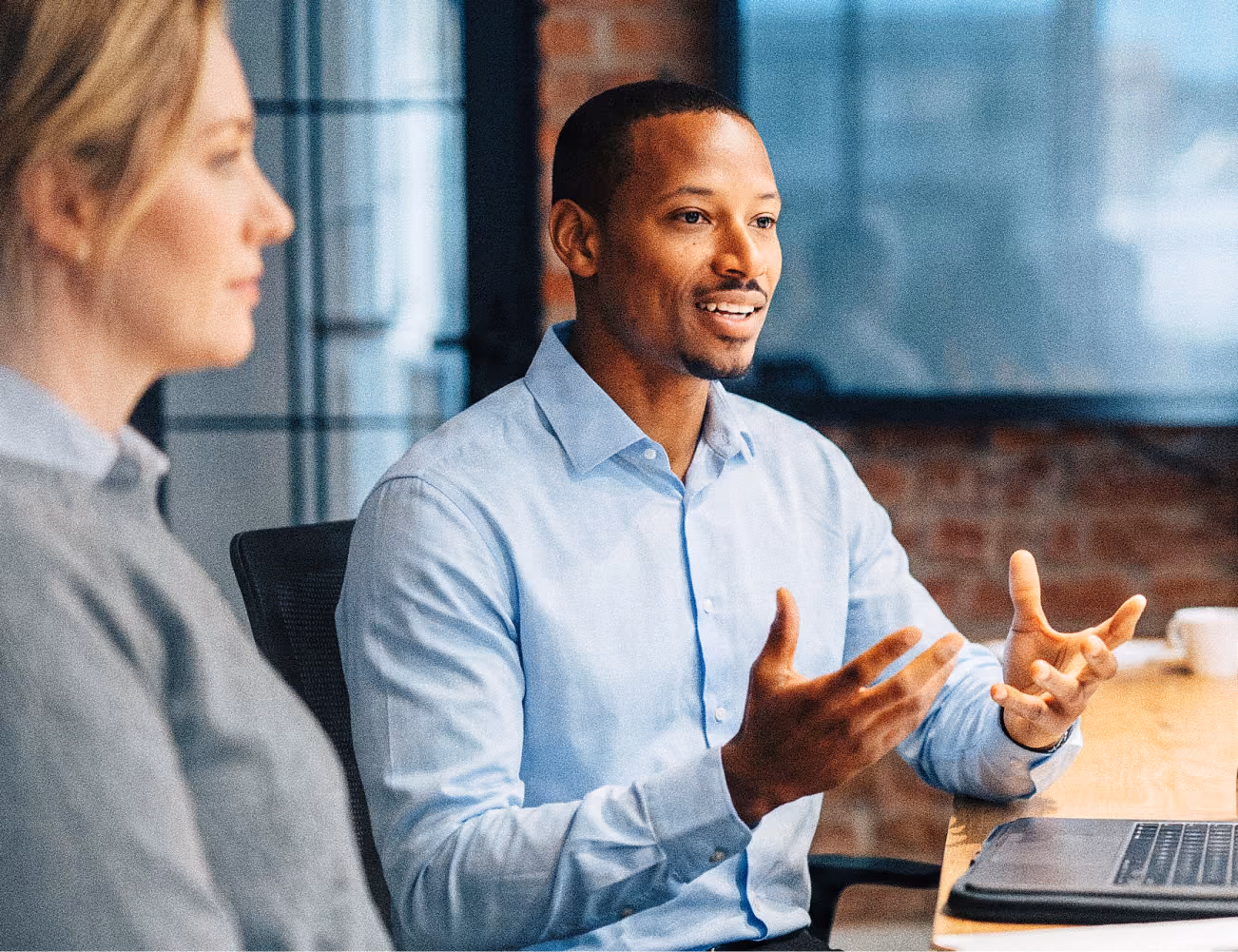 Two colleagues in conversation at a meeting table