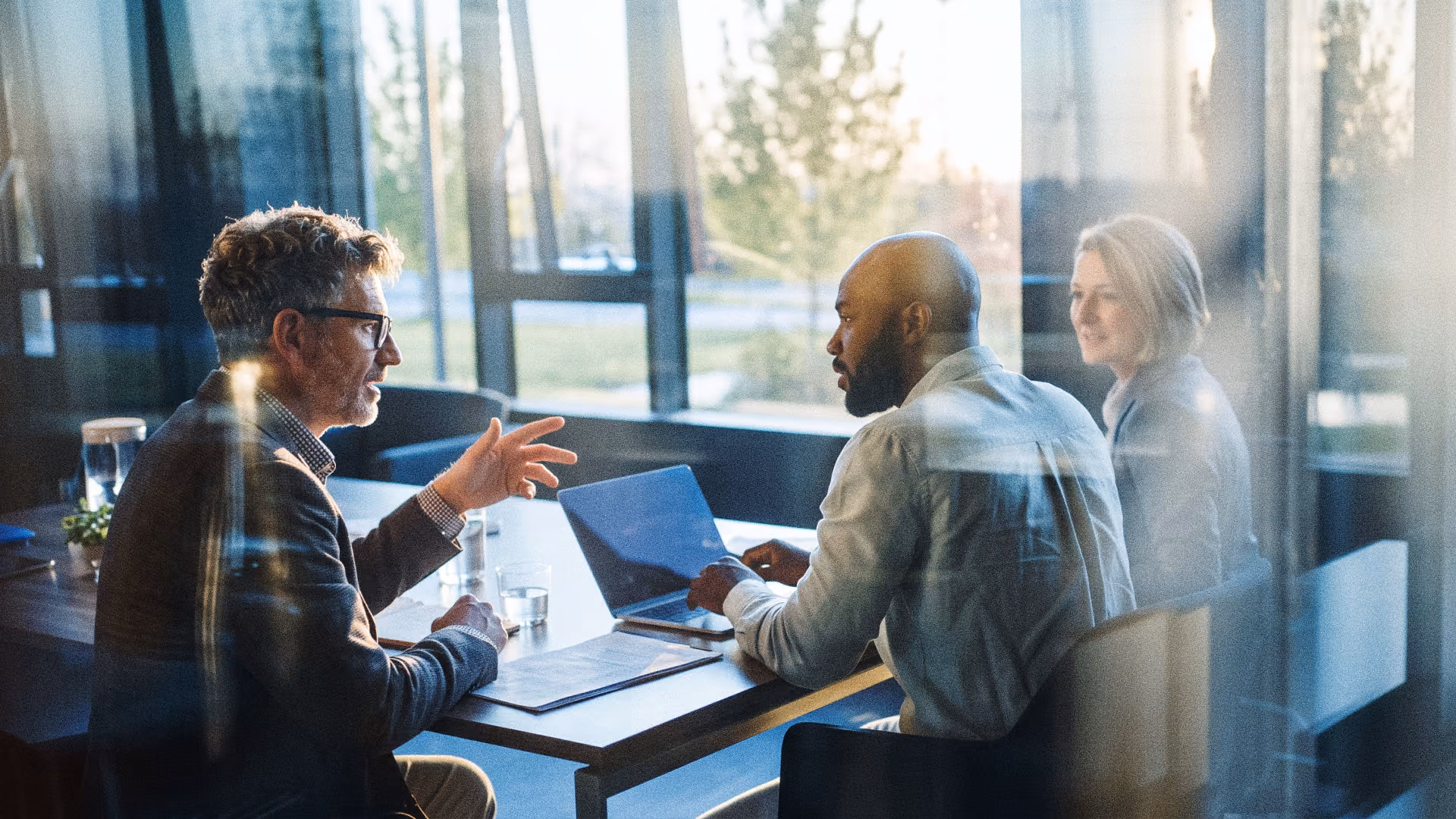 Colleagues talking around a table in a bright office