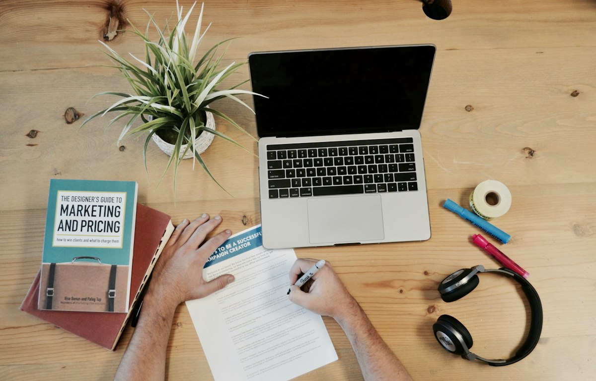 Laptop and marketing planning materials arranged on a desk