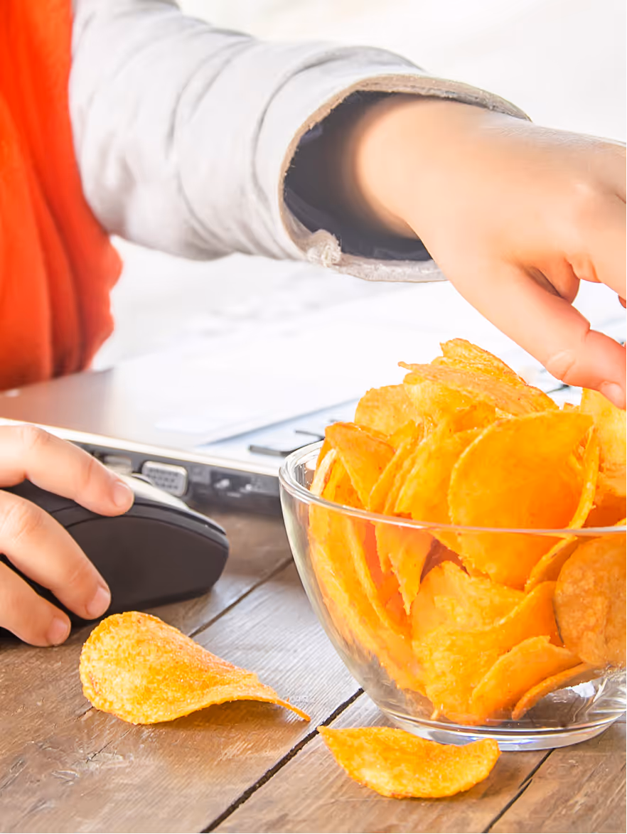 Hands preparing a bowl of baked potato chips on a kitchen counter.
