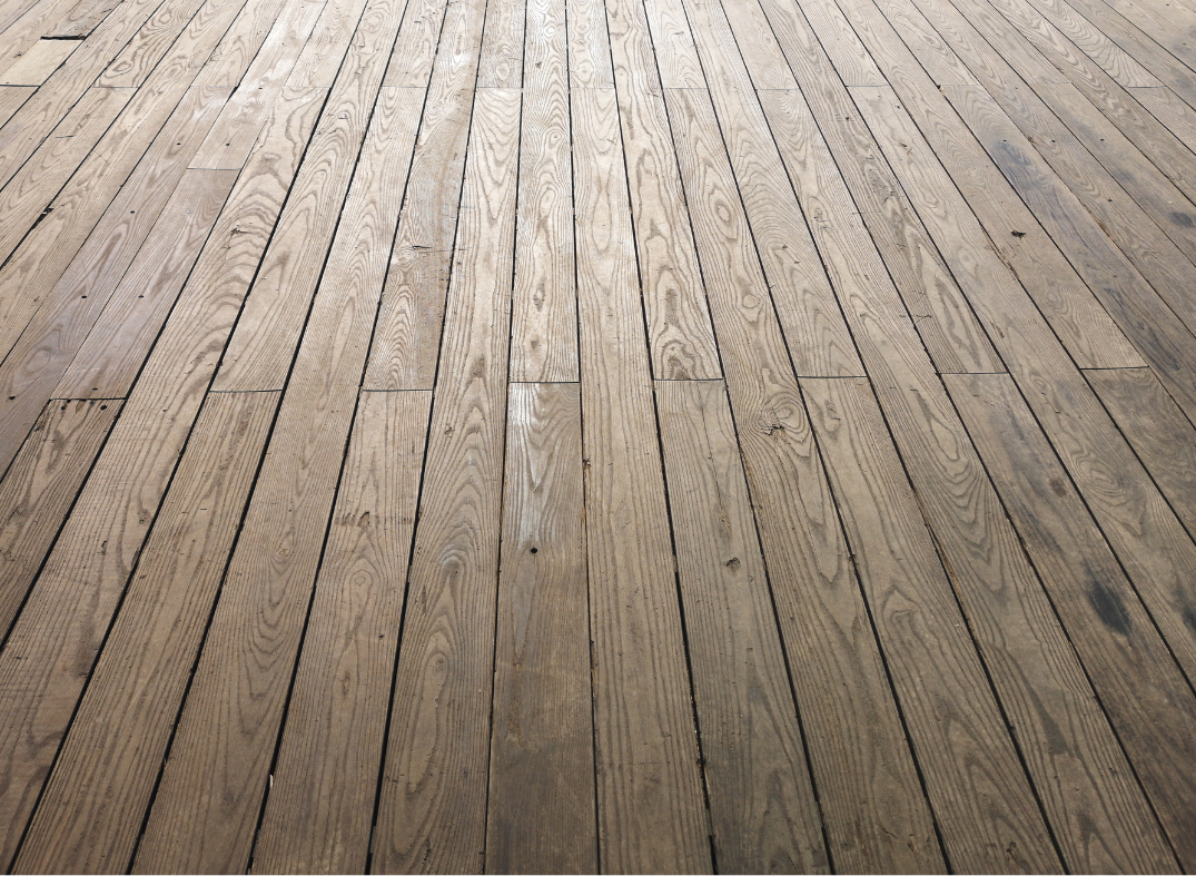 Photo of a wood floor with vertical planks and a soft spotlight