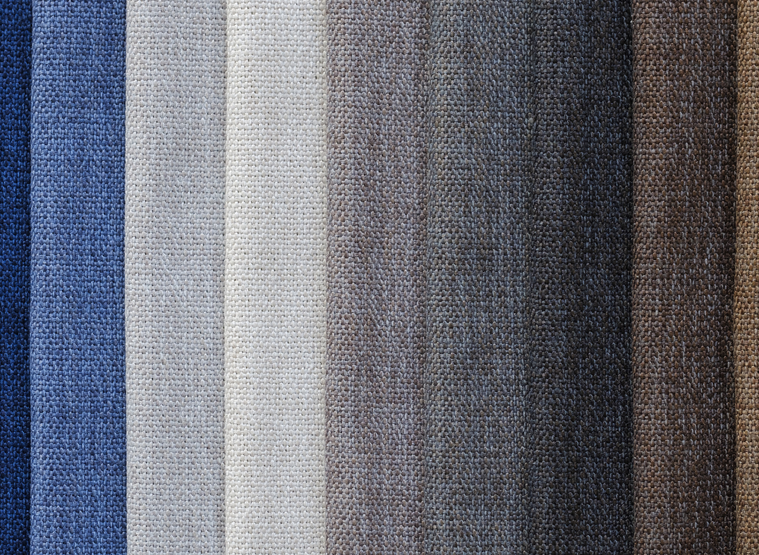 Horizontal stripes of fabric bolts ranging from blue to white to gray to brown.