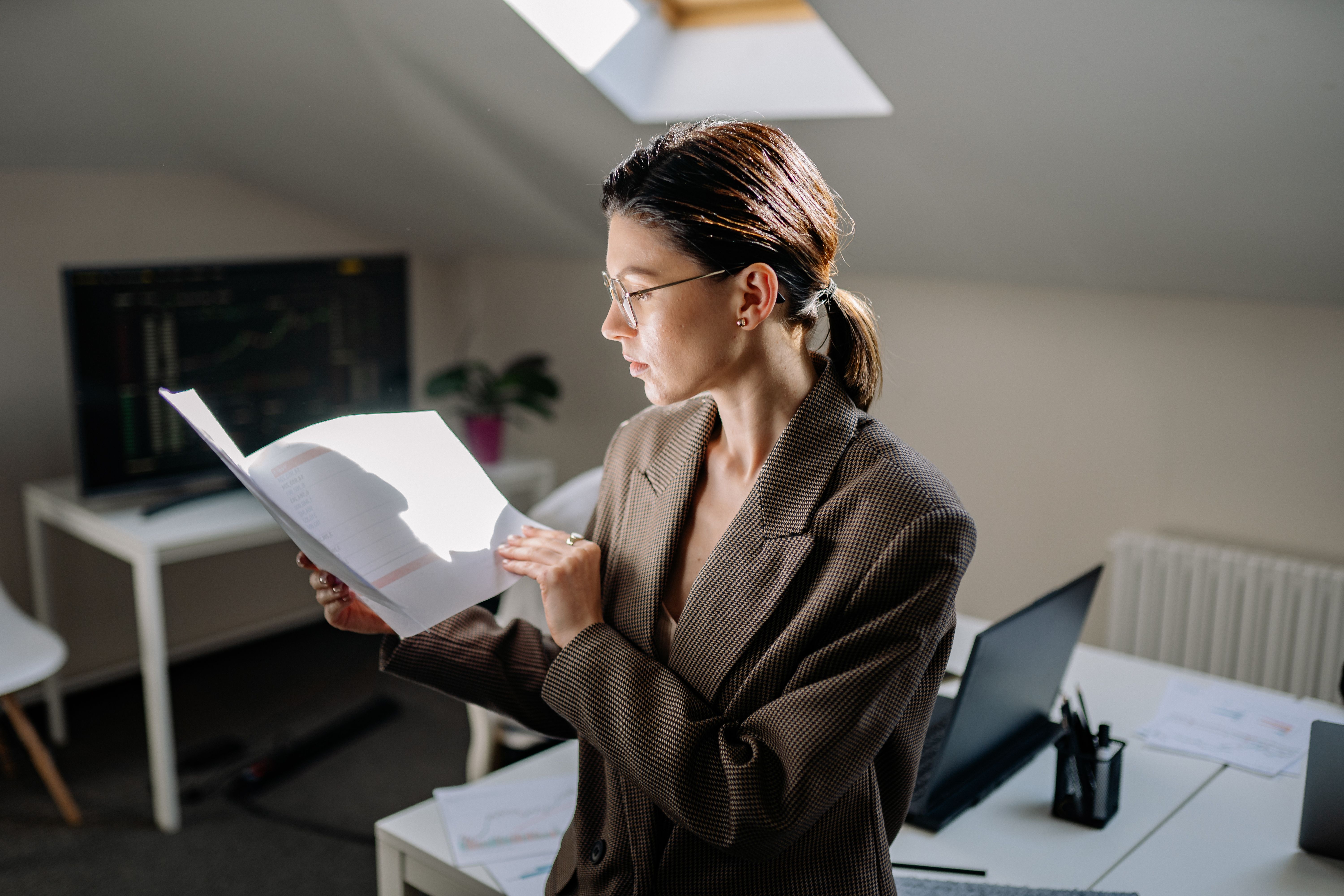 Business owner reviewing financial paperwork at her desk