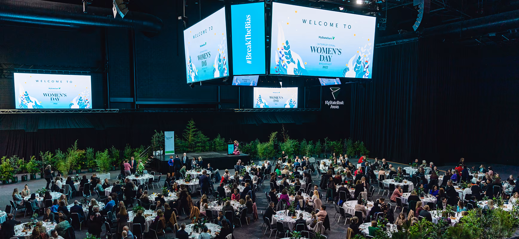 Large indoor event with round tables and attendees at International Women's Day 2022 at MyState Bank Arena.