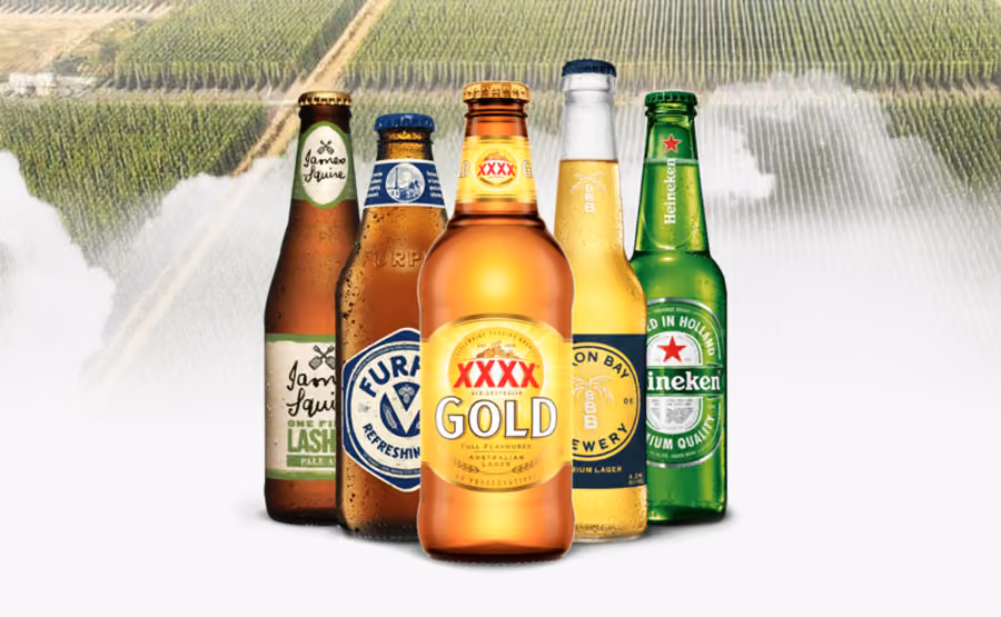 Five different beer bottles including XXXX Gold, Heineken, and James Squire with vineyard background.