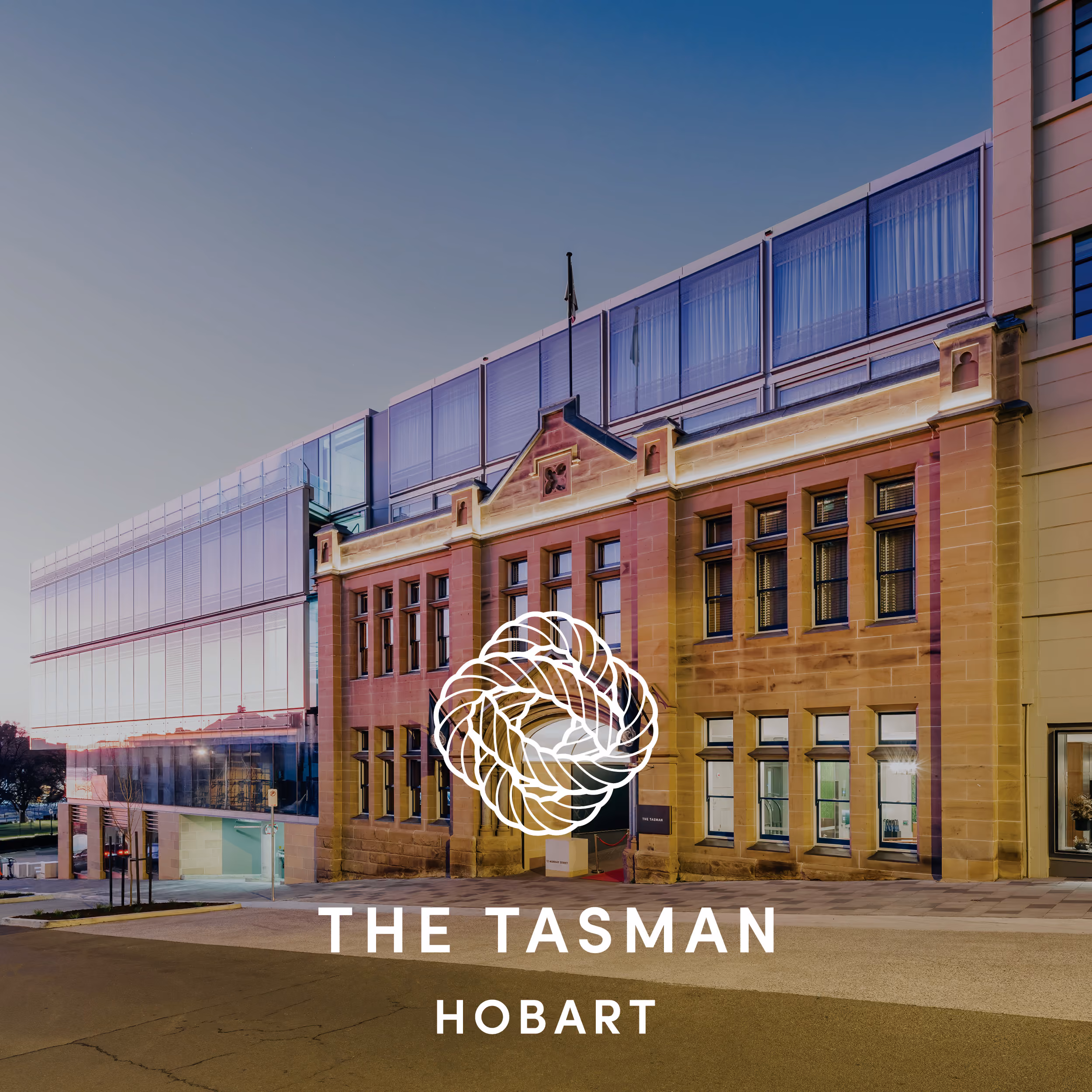 The Tasman building in Hobart combines historic sandstone with modern glass architecture at dusk.