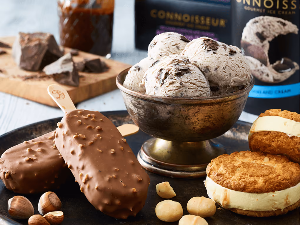 Chocolate-coated ice cream bars, scoops of chocolate chip ice cream, and ice cream sandwiches on a tray.