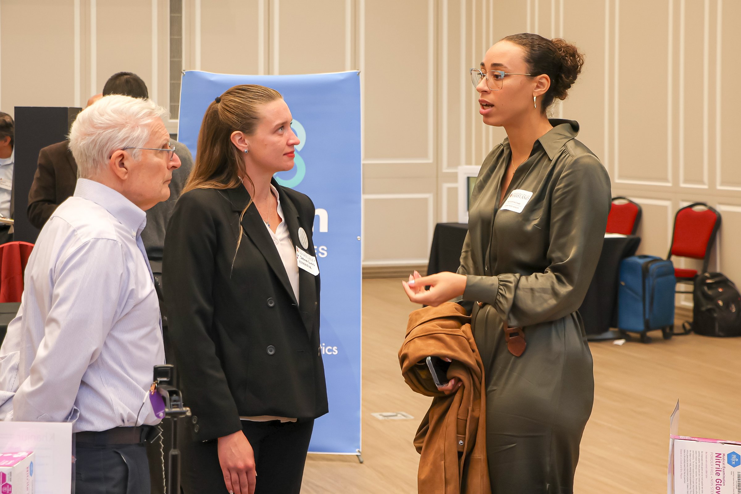 Attendees at an exhibitor table in the exhibit hall
