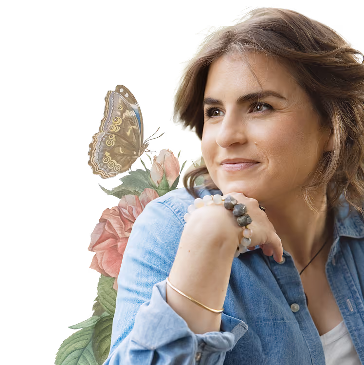 Leah Hoffman in denim shirt resting her chin on her hand with floral background and butterfly.