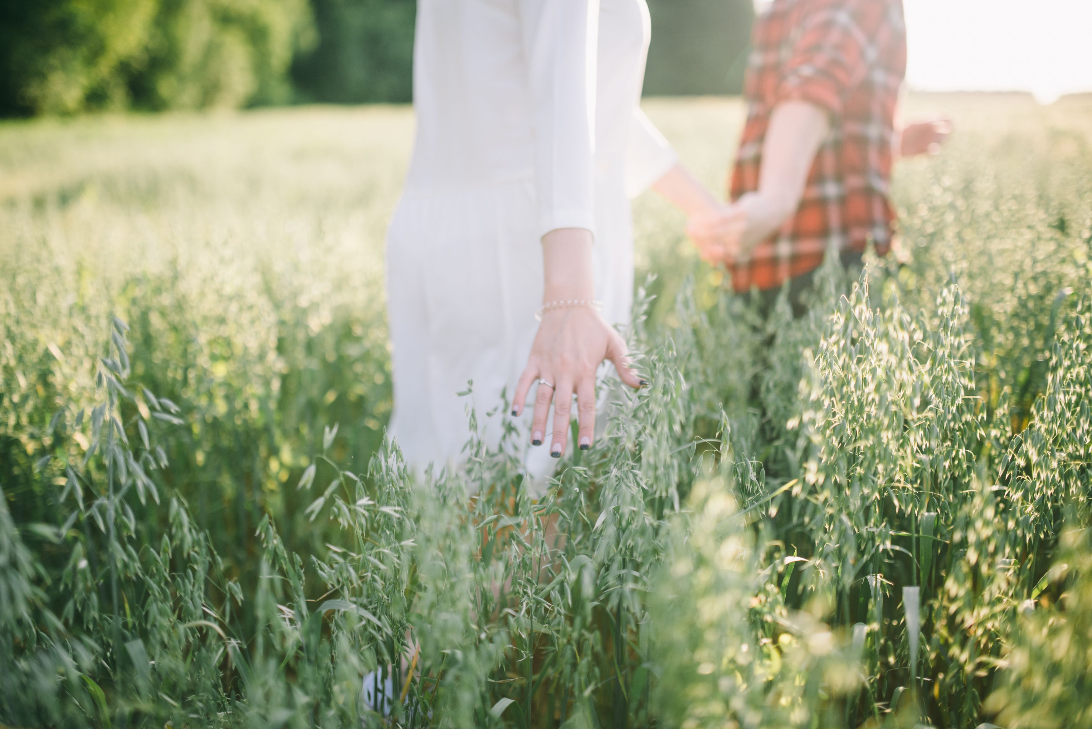 Couple embracing closely with foreheads touching near calm lake at sunset.