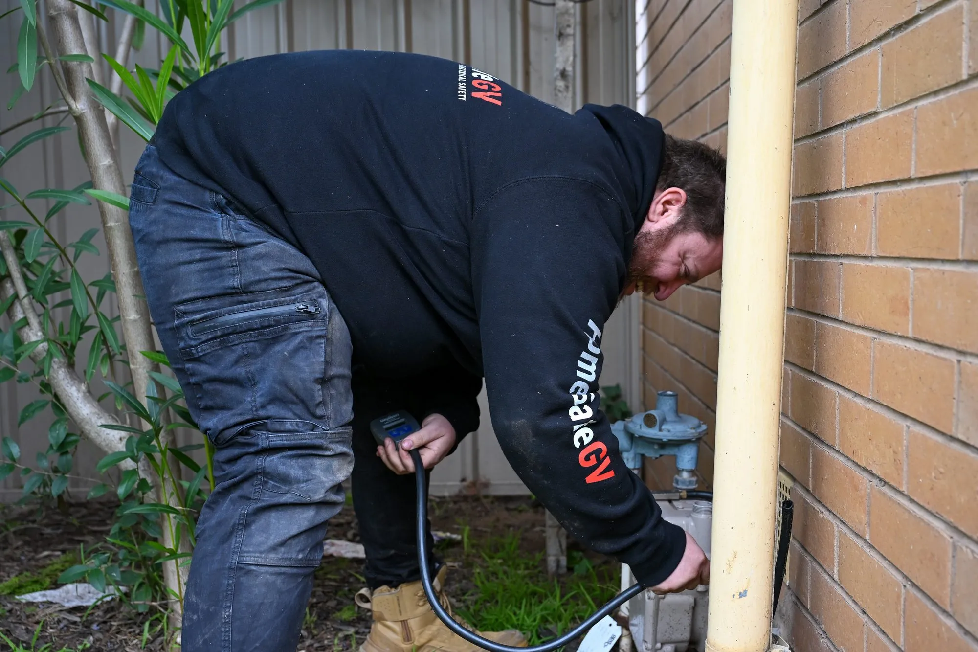 A HomeSafeGV gas plumber testing a gas appliance during a safety check
