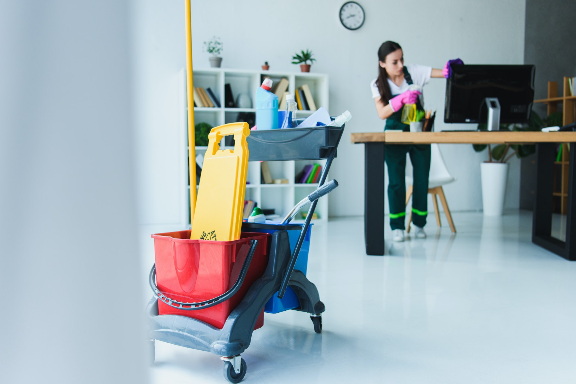 Cleaning professional using commercial cleaning equipment in an office
