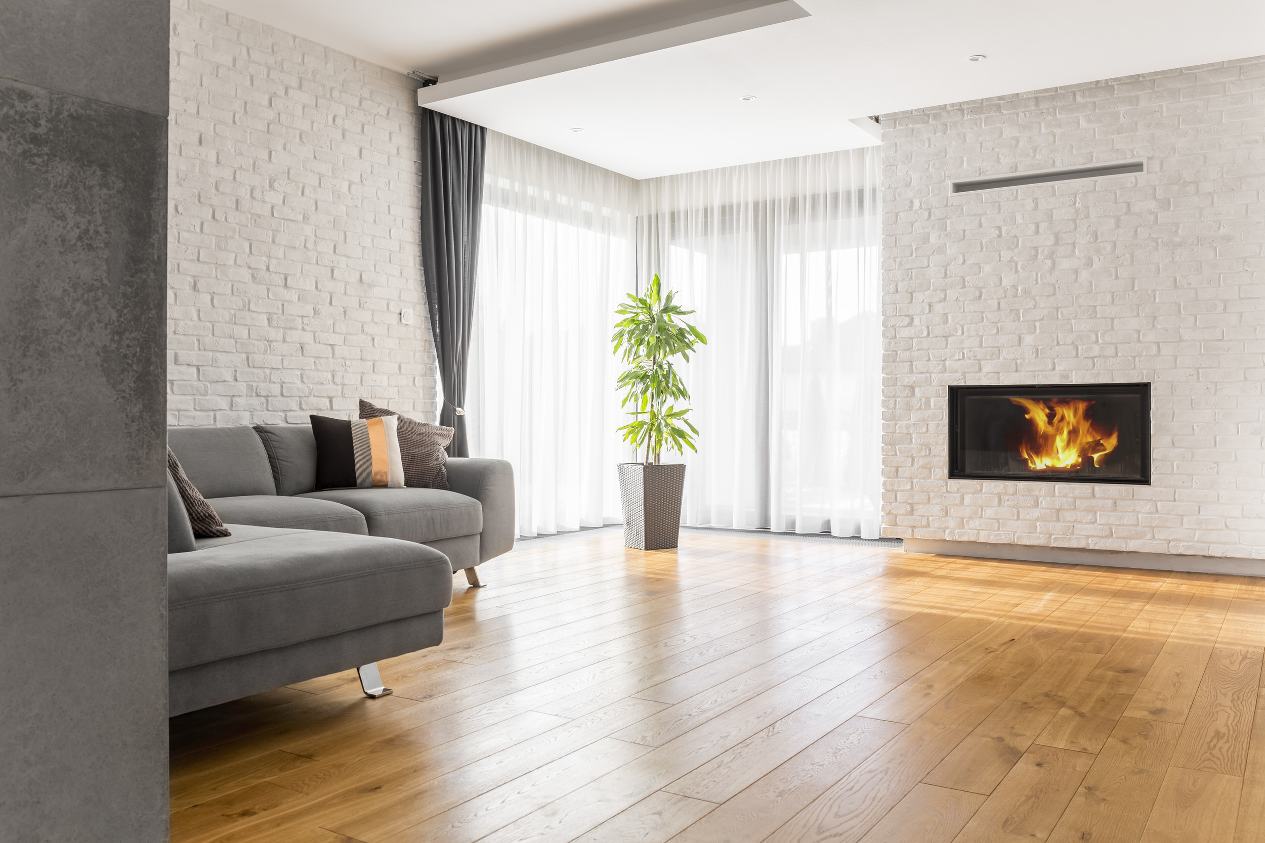 Living room with polished hardwood flooring, fireplace and sofa