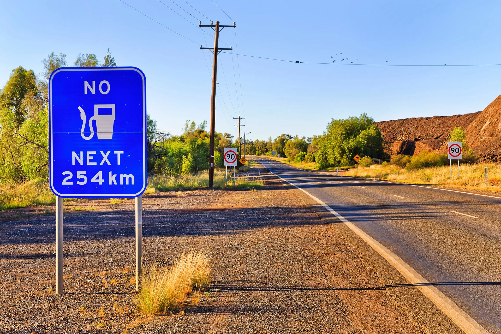 Remote highway landscape with a no fuel for long distances sign