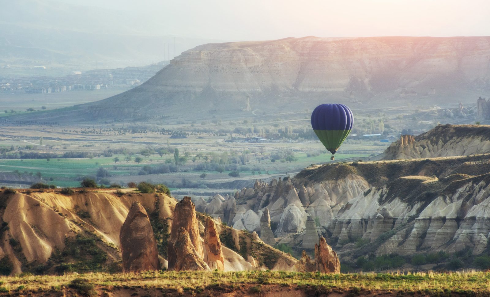 Hot air balloon over a canyon valley