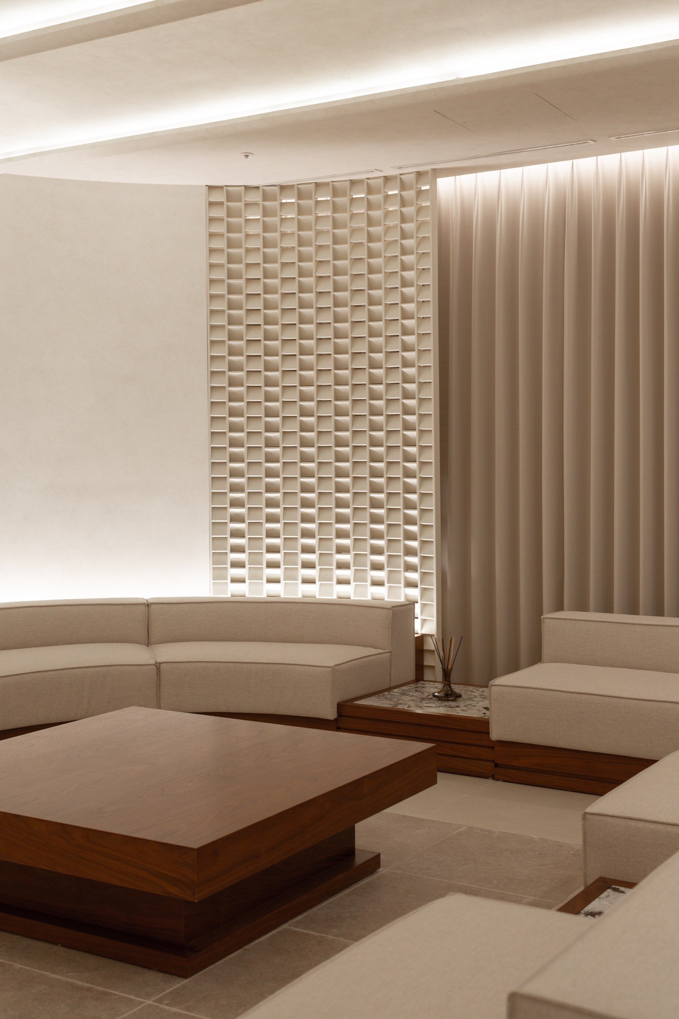 Private lounge with curved seating and softly lit textured walls at Liftique Dermatology Clinic
