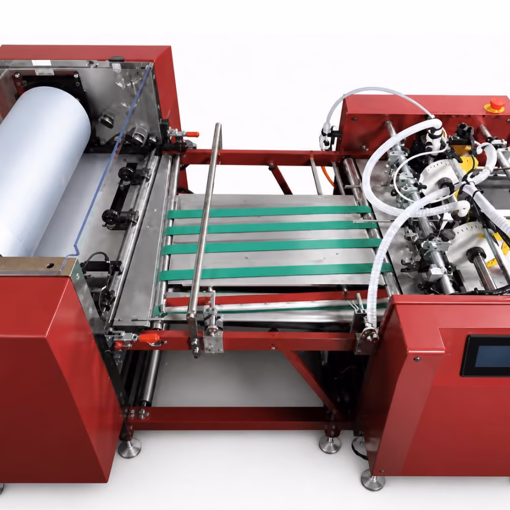 Red industrial packaging machine with a large roll of white material on the left and conveyor belts in the center, featuring tubes and mechanical components on the right side.
