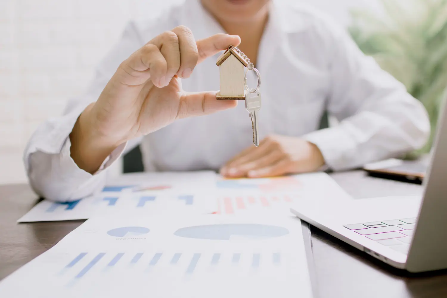 Professionnel montrant une clé et porte-clé de maison