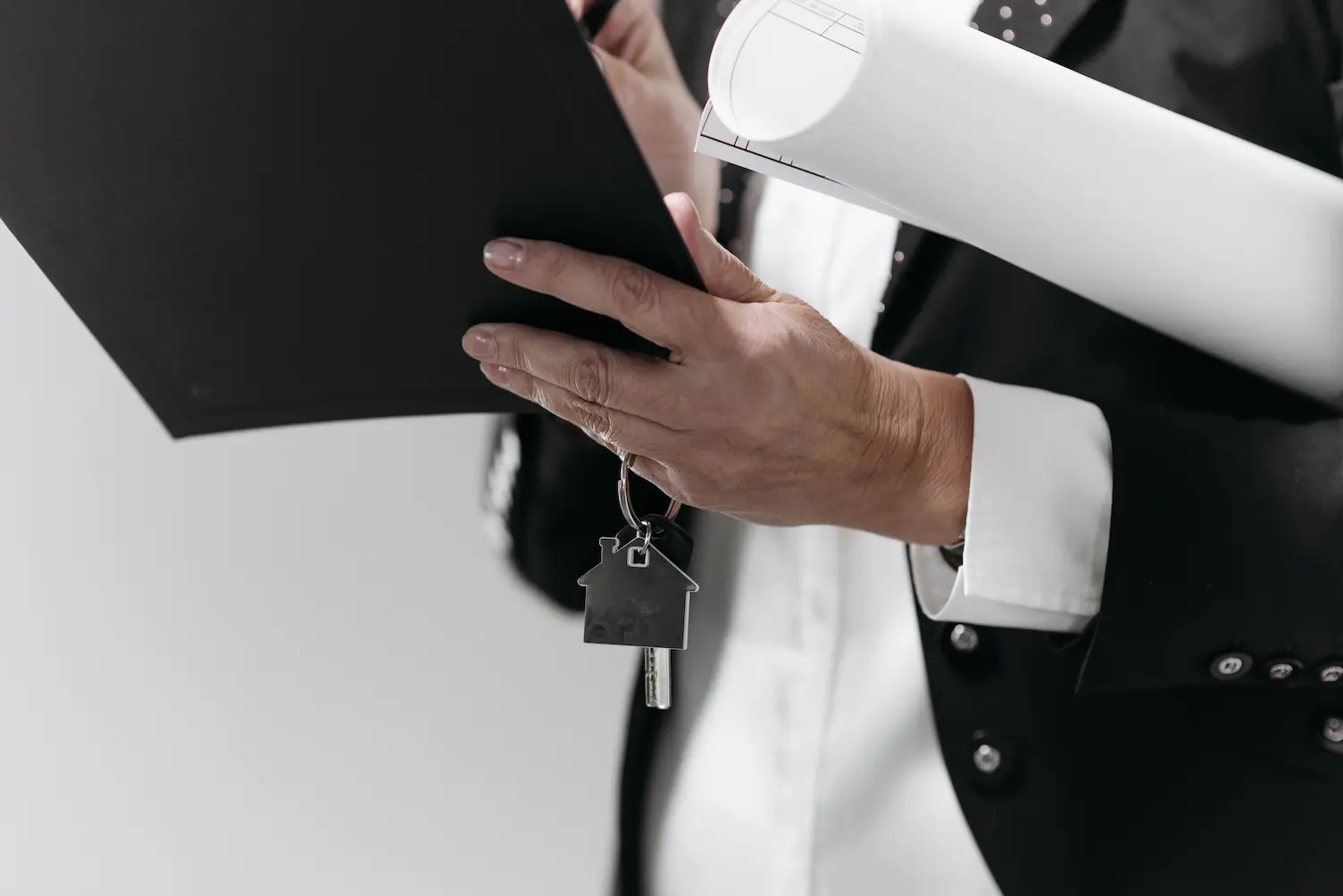 Gros plan d'un professionnel des affaires tenant une clé de maison et des plans