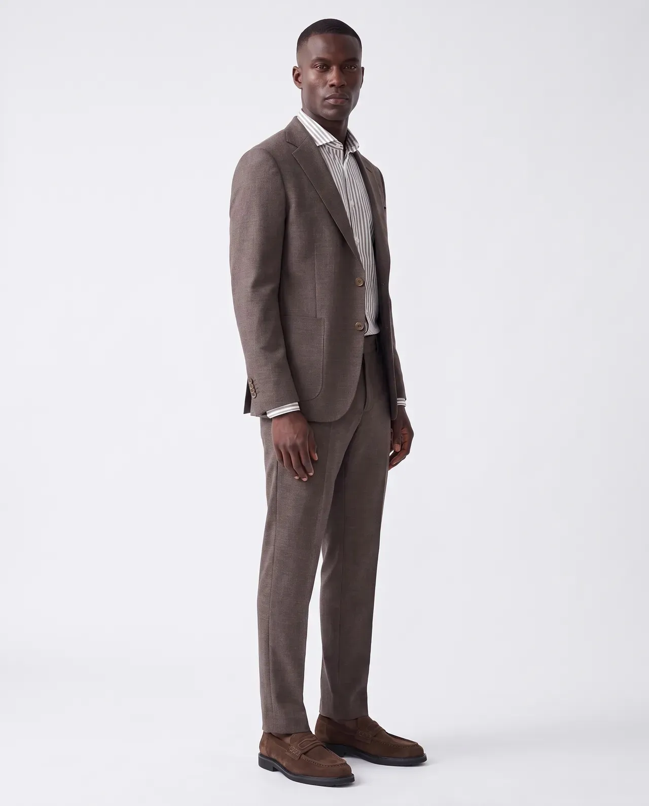 On-model productfoto: man in een bruin pak met gestreept overhemd en bruine schoenen, volledige lengte