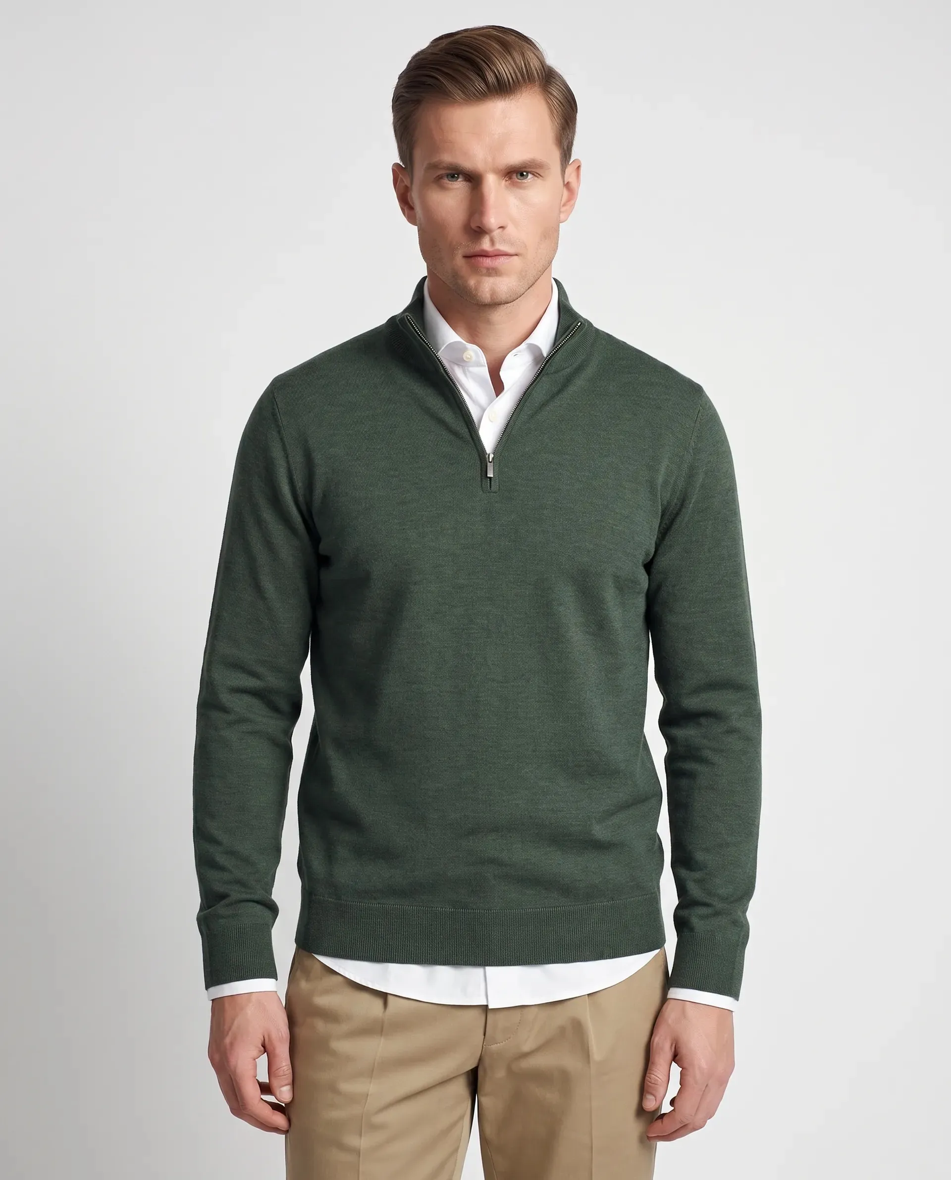 On-model productfoto: man in een donkergroene trui met korte rits over een wit overhemd en een beige broek