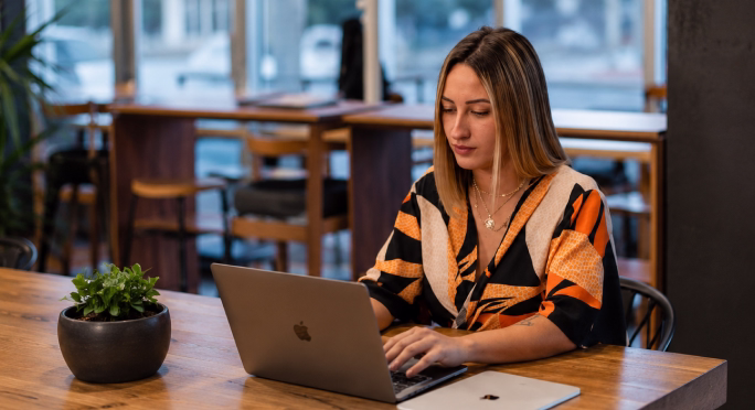 Analyst reviewing financial figures on a laptop in a cafe