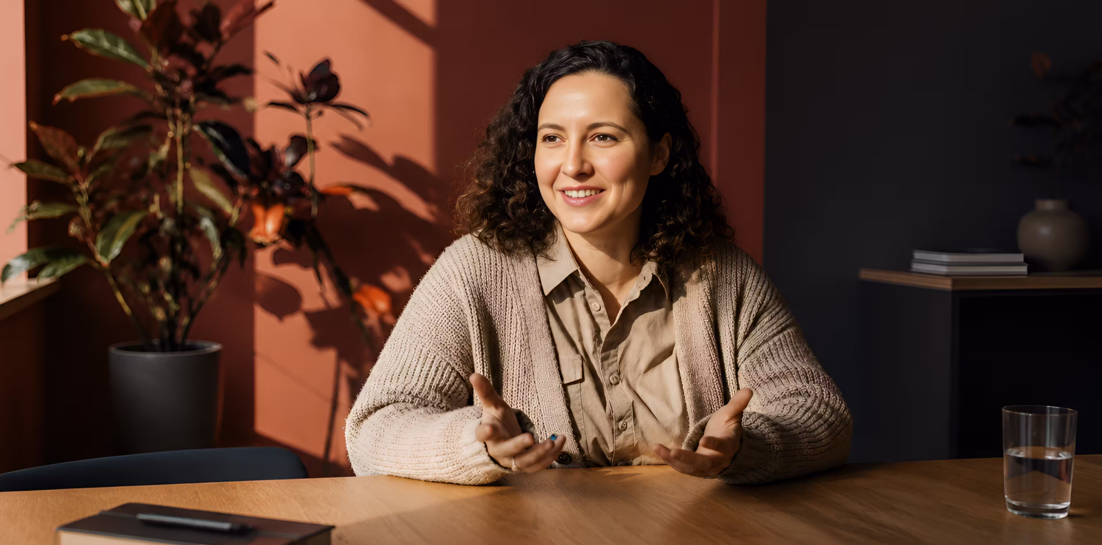 Client speaking with an adviser across a table in a warm-lit office