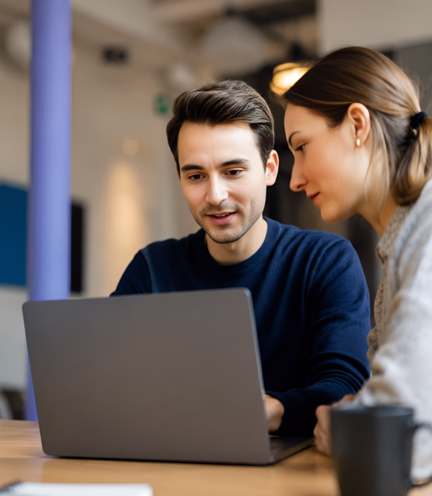 Two colleagues reviewing investment figures on a laptop