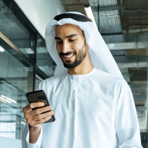 Arab man in traditional clothing using a smartphone