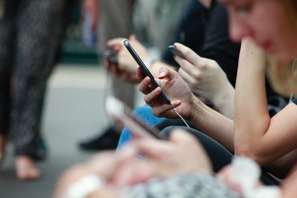 Multiple people using their phone outside