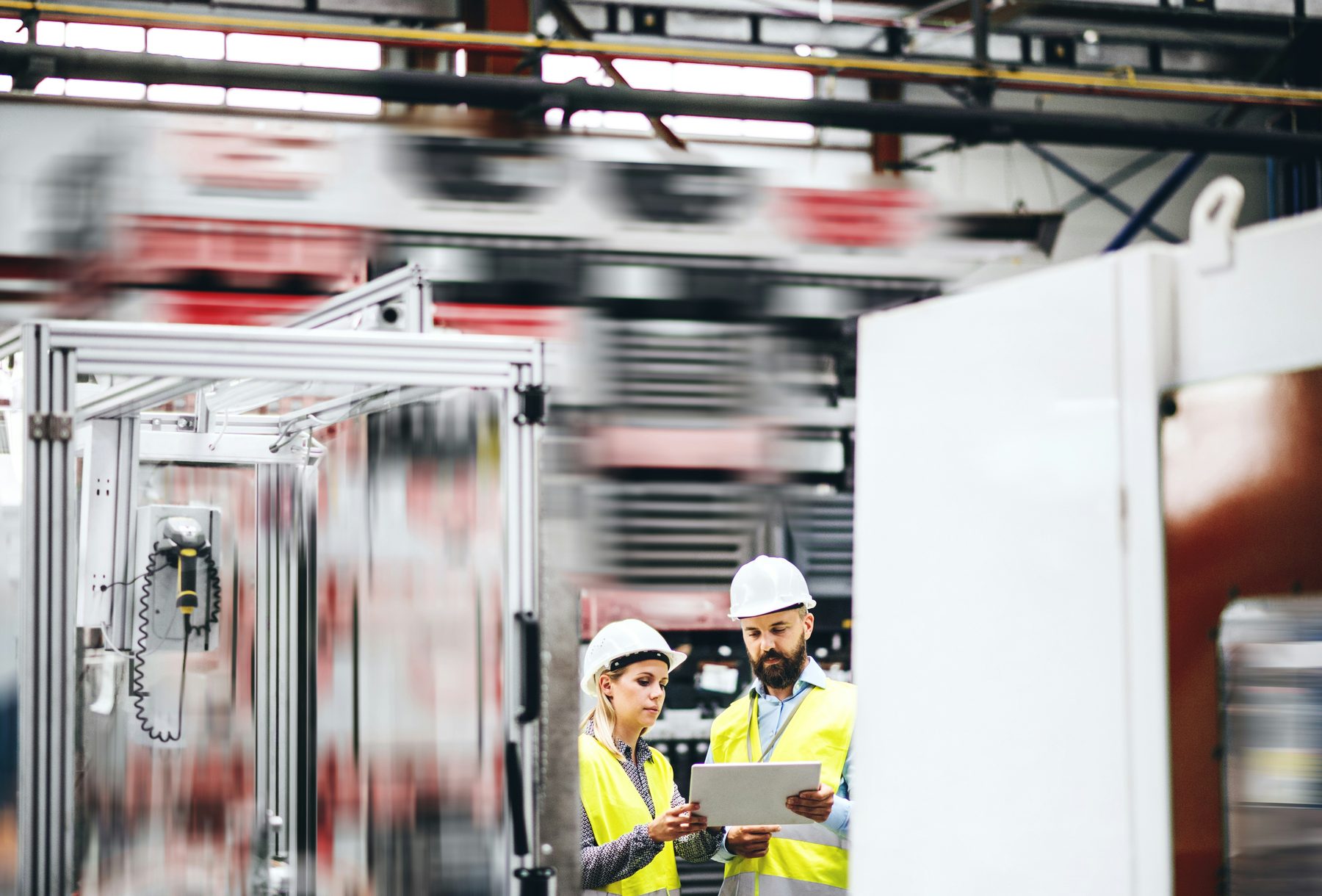 Two engineers reviewing a tablet on site