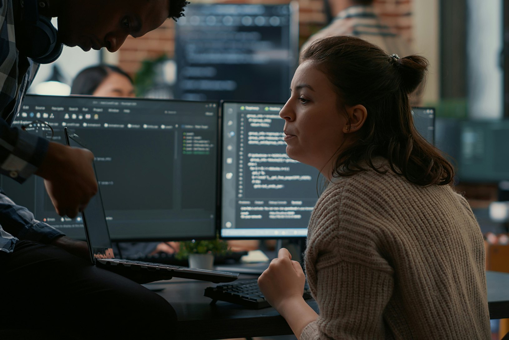 Two developers reviewing code on screen