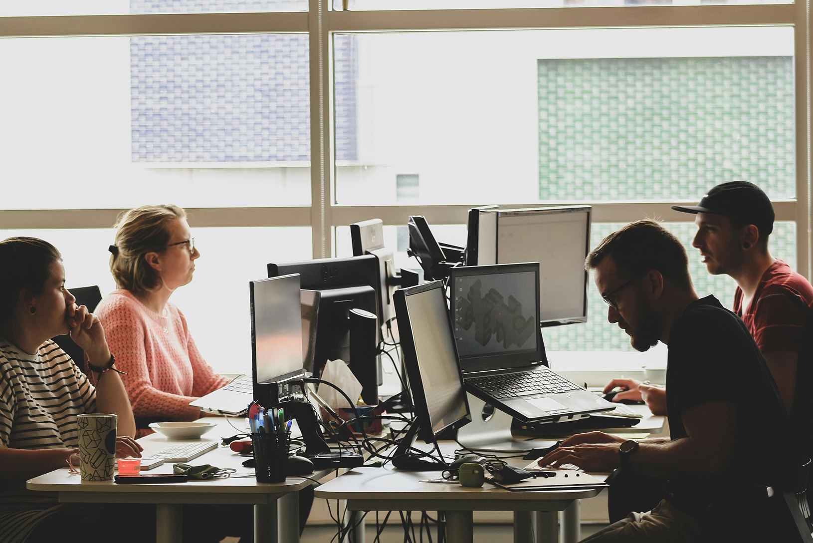 Team working together at desks by a window
