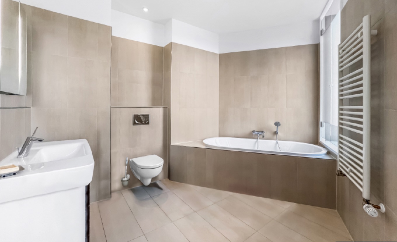 Masterbad mit Badewanne und großformatigen Fliesen