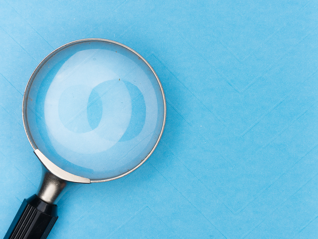 A magnifying glass on a blue background representing api attack